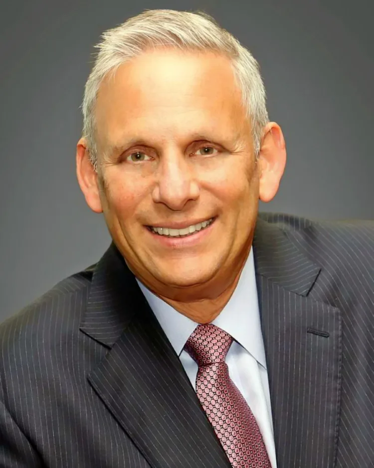 Photo: White male with gray hair smiling. 